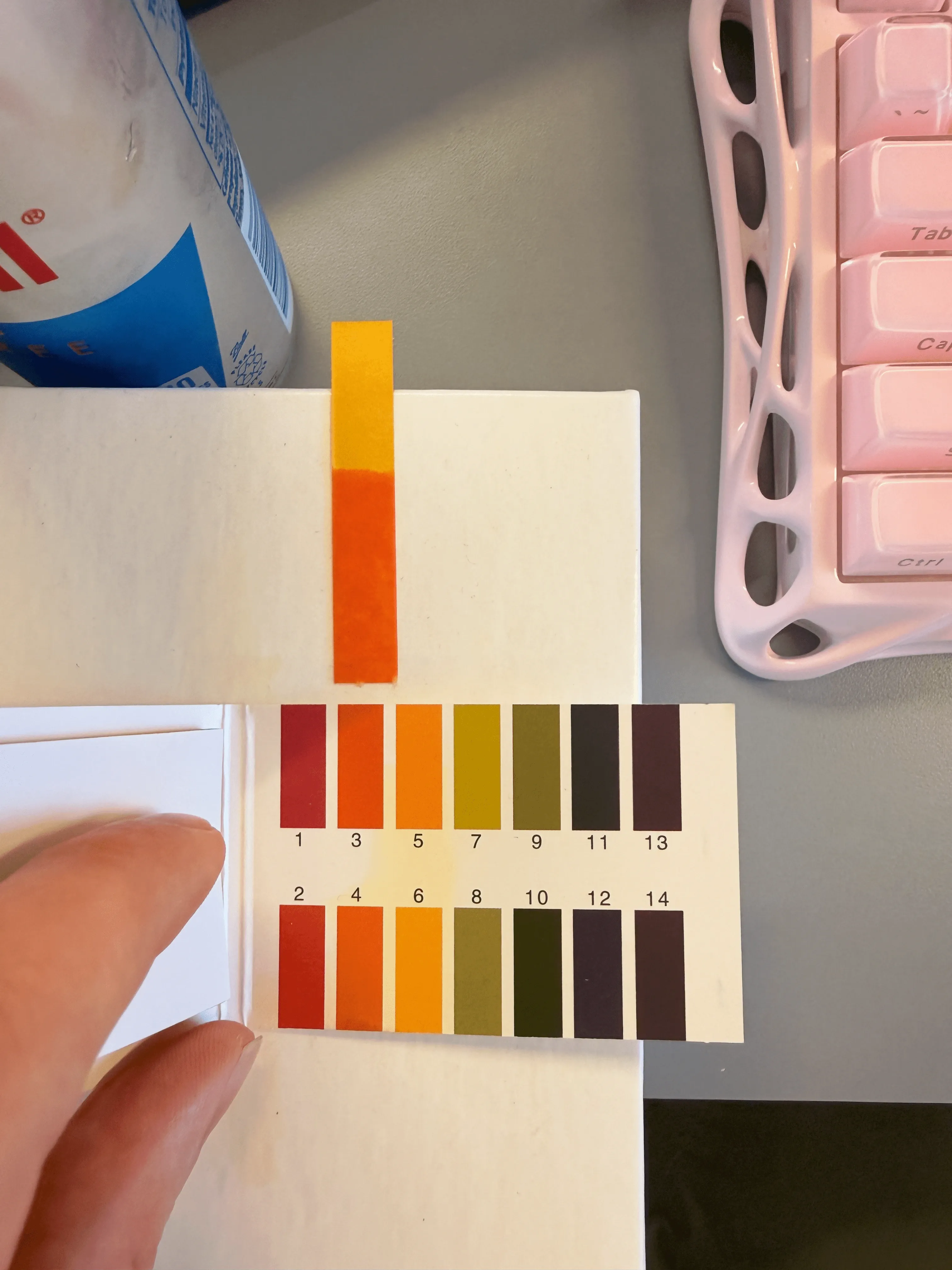 A pH test strip showing that Red Bull has a pH between 3 and 4